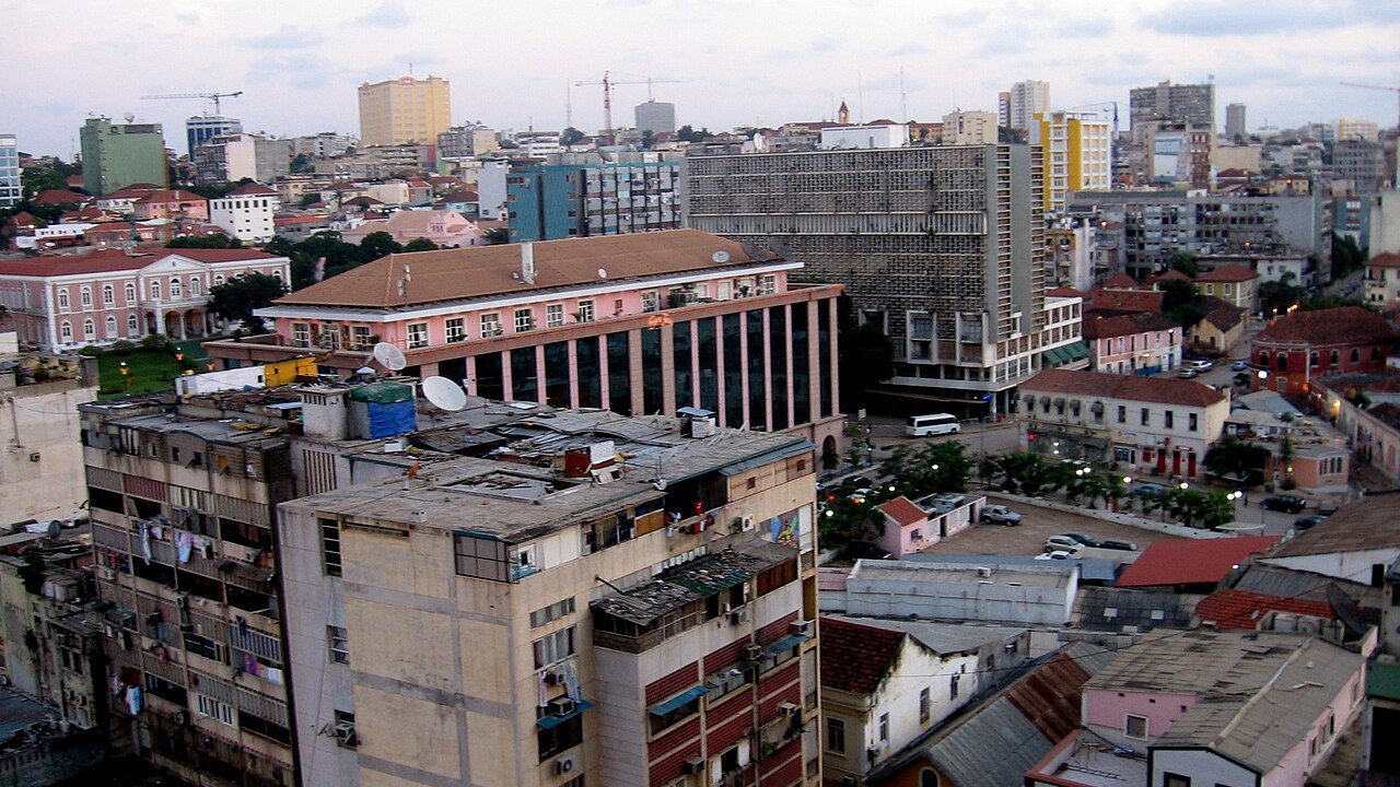 Rooftops and apartment blocks in central Luanda at dusk with newer towers behind