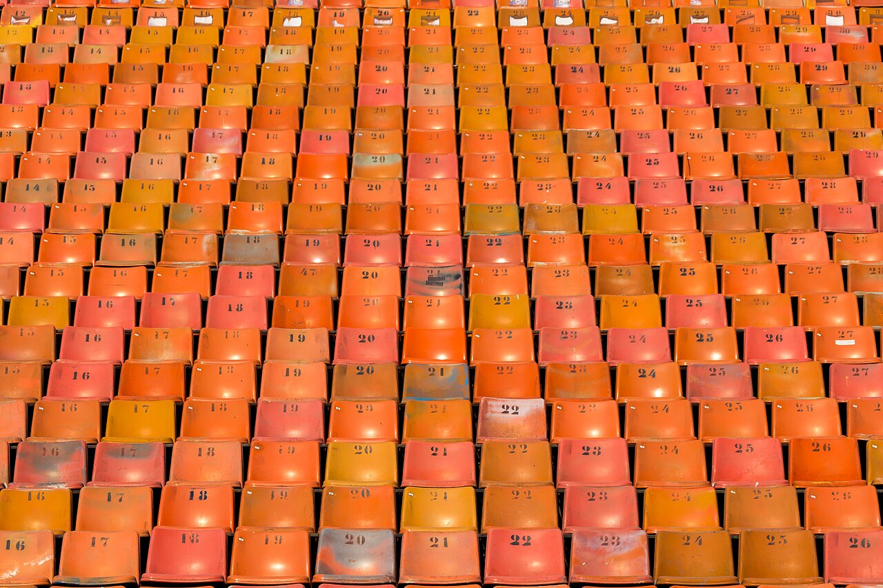 Rows of numbered orange and red seats in the Pacaembu stadium in São Paulo.
