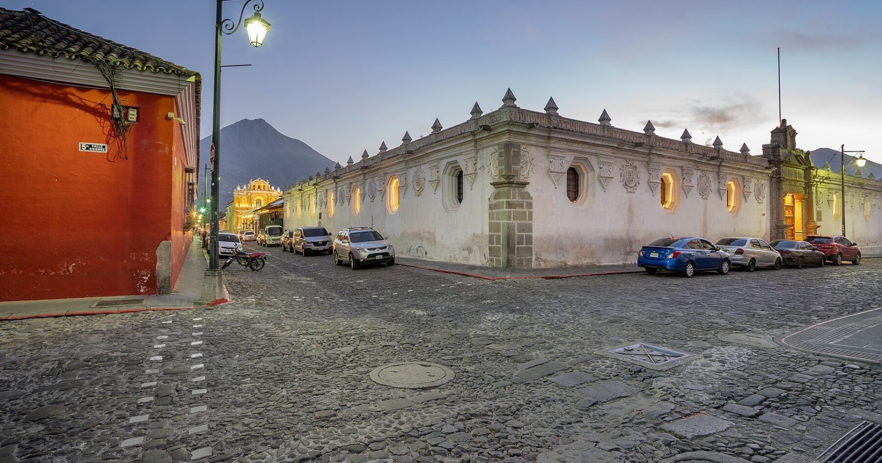 Cobbled street in Antigua Guatemala at dusk with a volcano behind