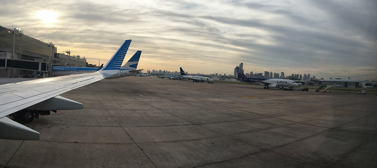 Aerolíneas Argentinas and LAN passenger jets on the apron at Aeroparque Jorge Newbery, with the Buenos Aires skyline behind