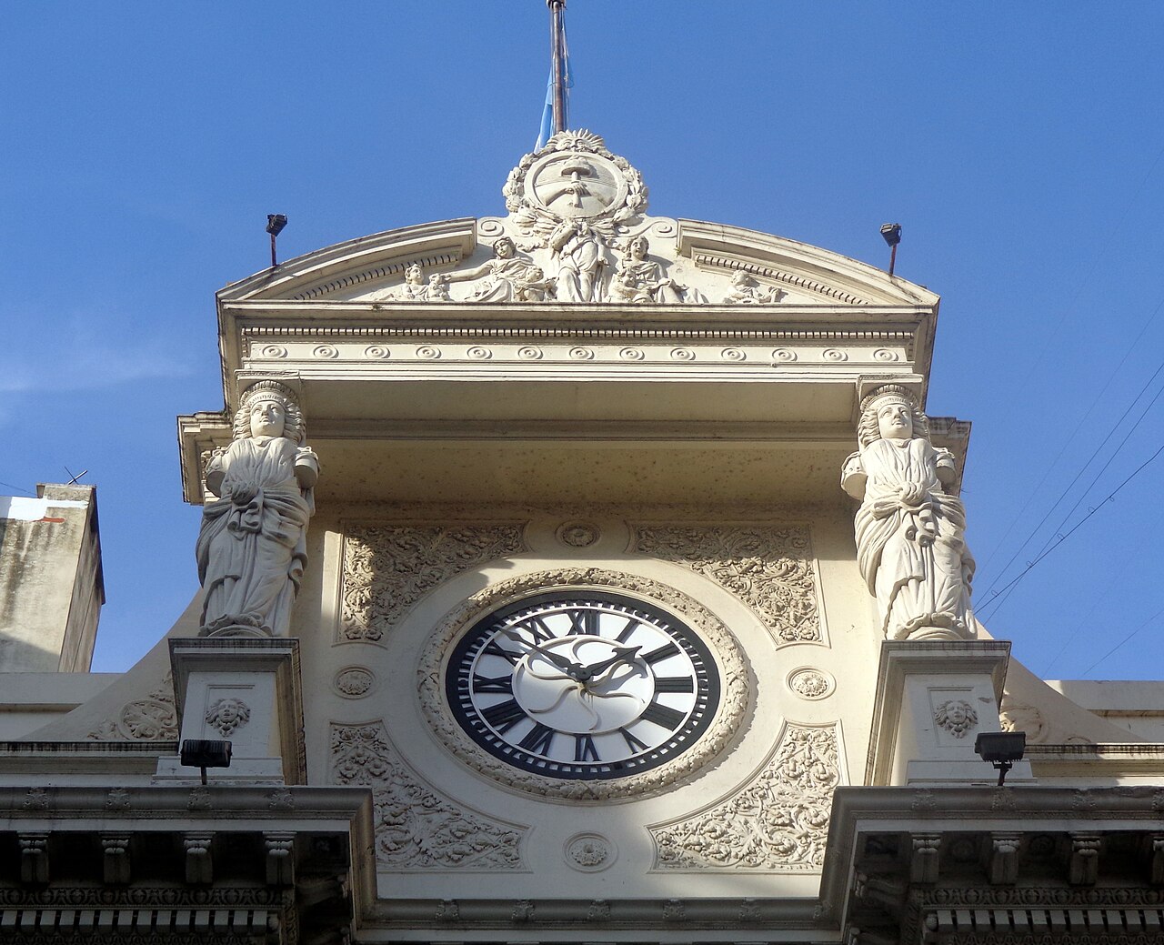 Clock and statues on the roofline of the Argentine central bank building on San Martín street, Buenos Aires