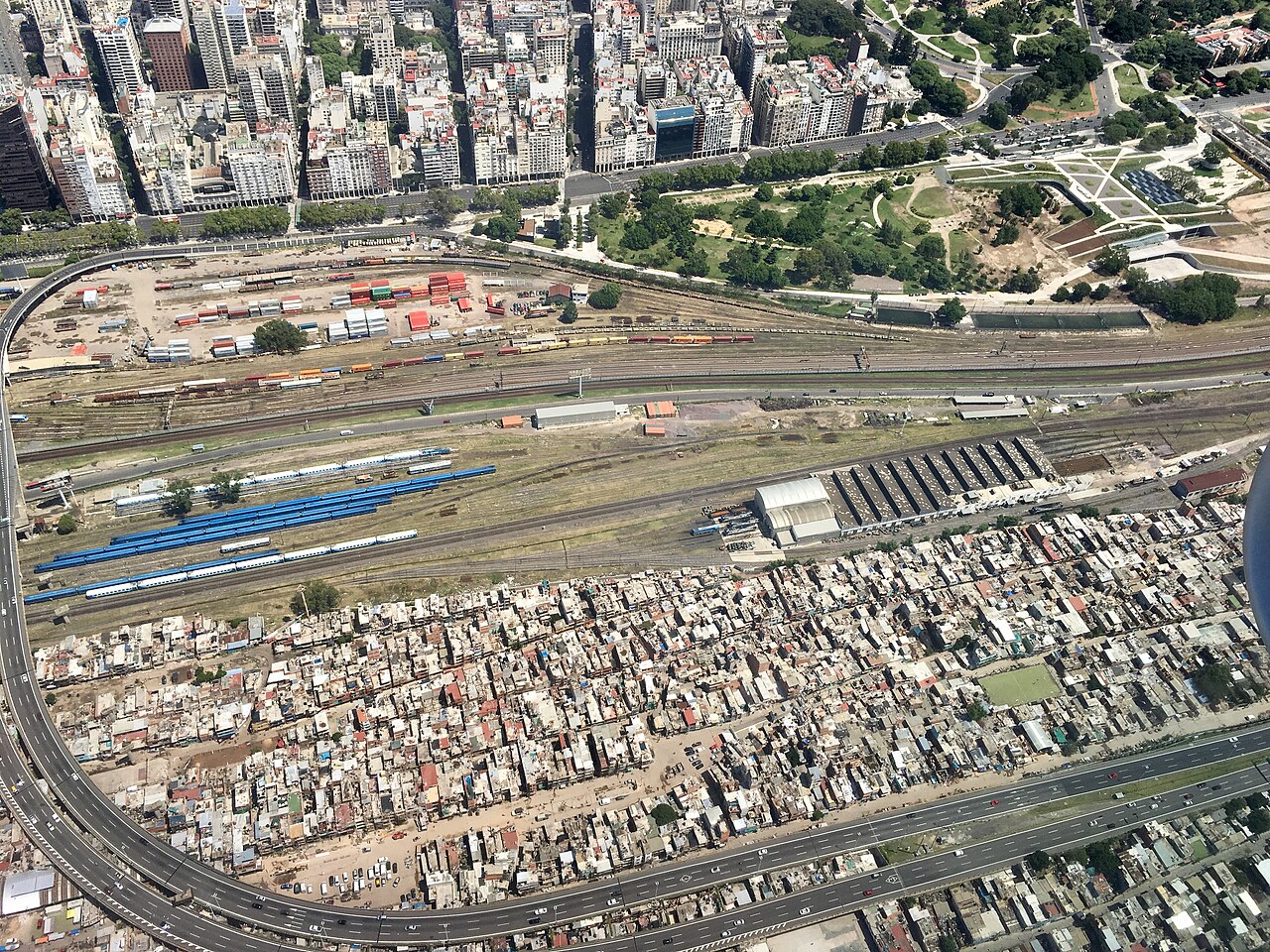 Aerial view of the Villa 31 bis settlement beside rail yards, a motorway and high-rise blocks in Buenos Aires