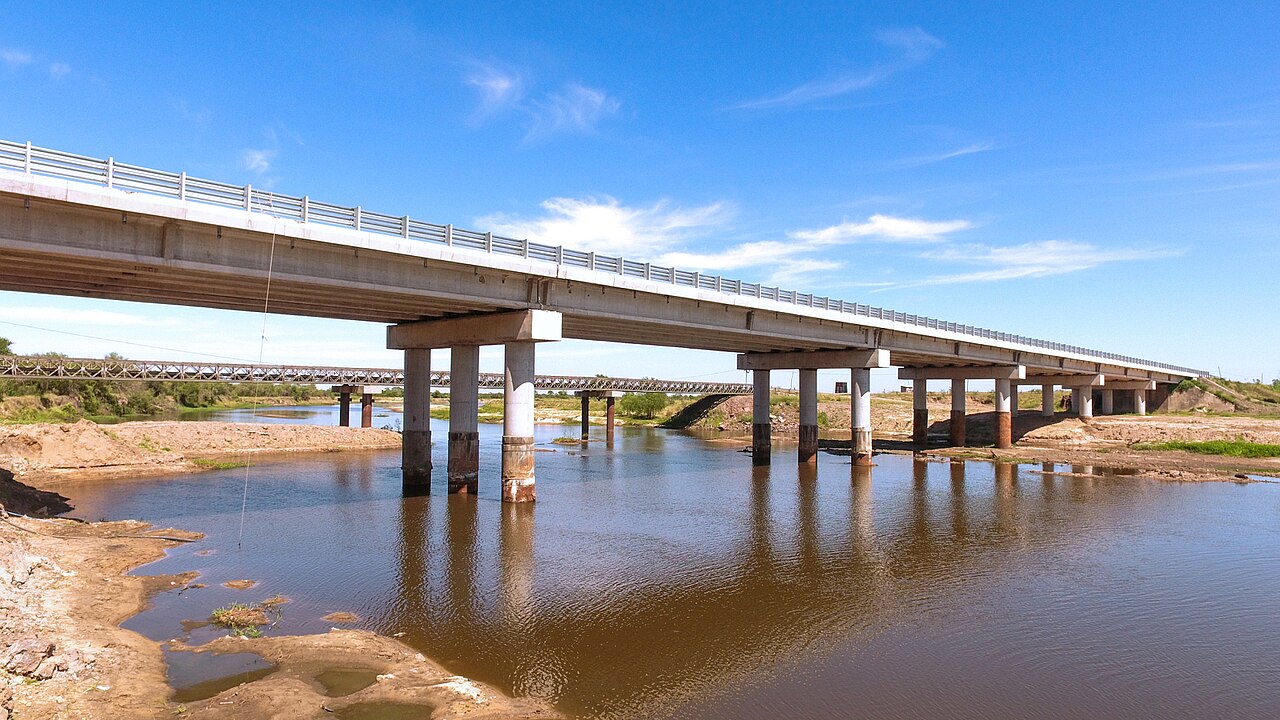 A new concrete road bridge on National Route 12 crossing the Guazú stream in Corrientes province, with an older steel bridge behind it