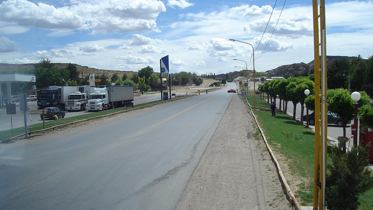 A YPF service station sign beside Route 237 in Neuquén province, Argentina, with trucks parked at the roadside