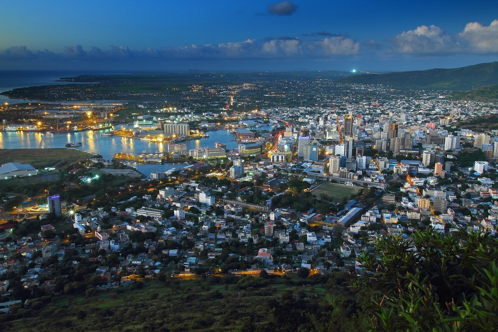 Port Louis, the capital of Mauritius, at dusk with the lit harbour and city towers seen from Mount Signal