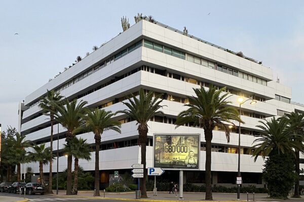 White multi-storey Attijariwafa bank office building with palm trees along the street in Casablanca