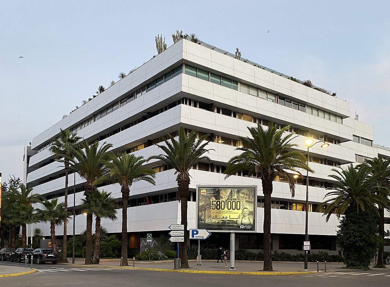 White multi-storey Attijariwafa bank office building with palm trees along the street in Casablanca