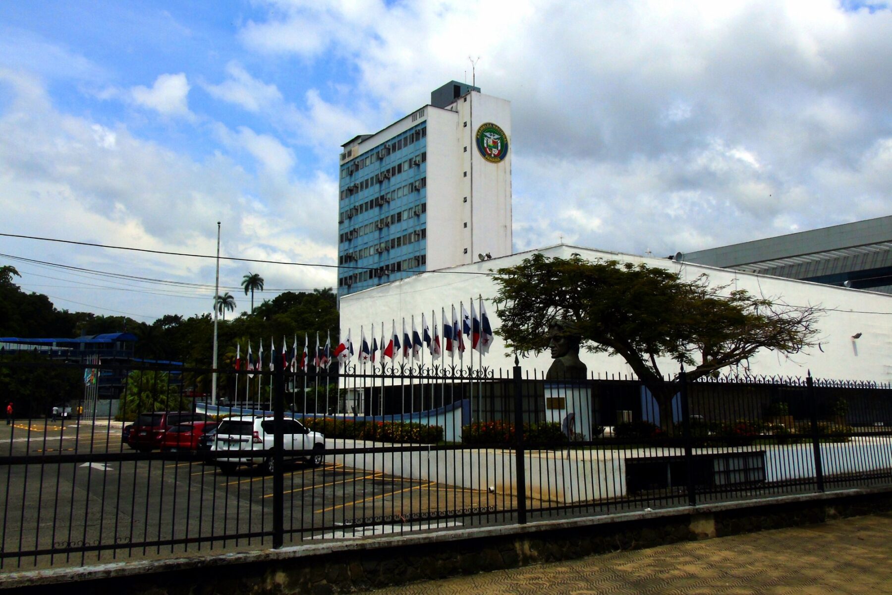 The tower and flag-lined front of Panama's National Assembly building behind an iron fence