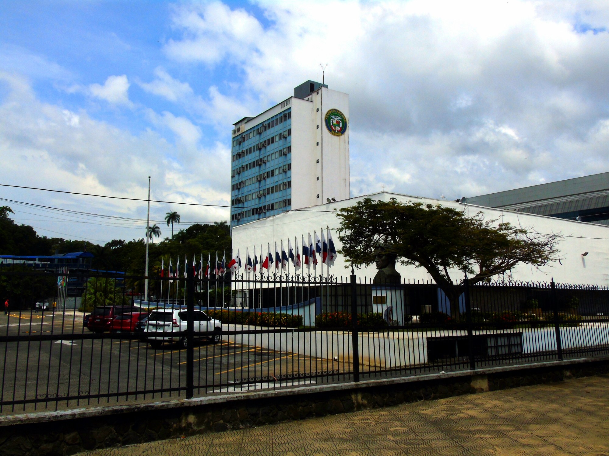 The tower and flag-lined front of Panama's National Assembly building behind an iron fence