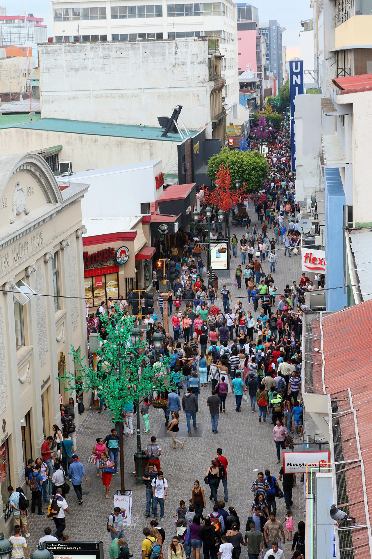 Crowds of pedestrians walking along the Avenida Central pedestrian boulevard in downtown San José, Costa Rica, seen from above.
