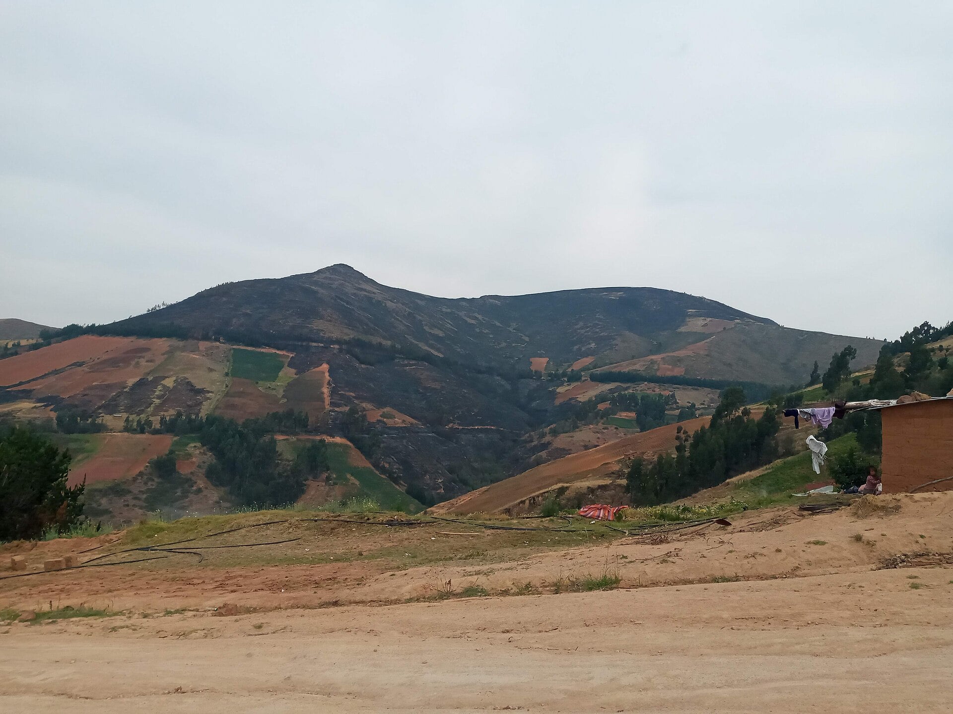 Burnt slopes of Santa Trinidad hill above farm plots in Tambillo, Ayacucho, Peru