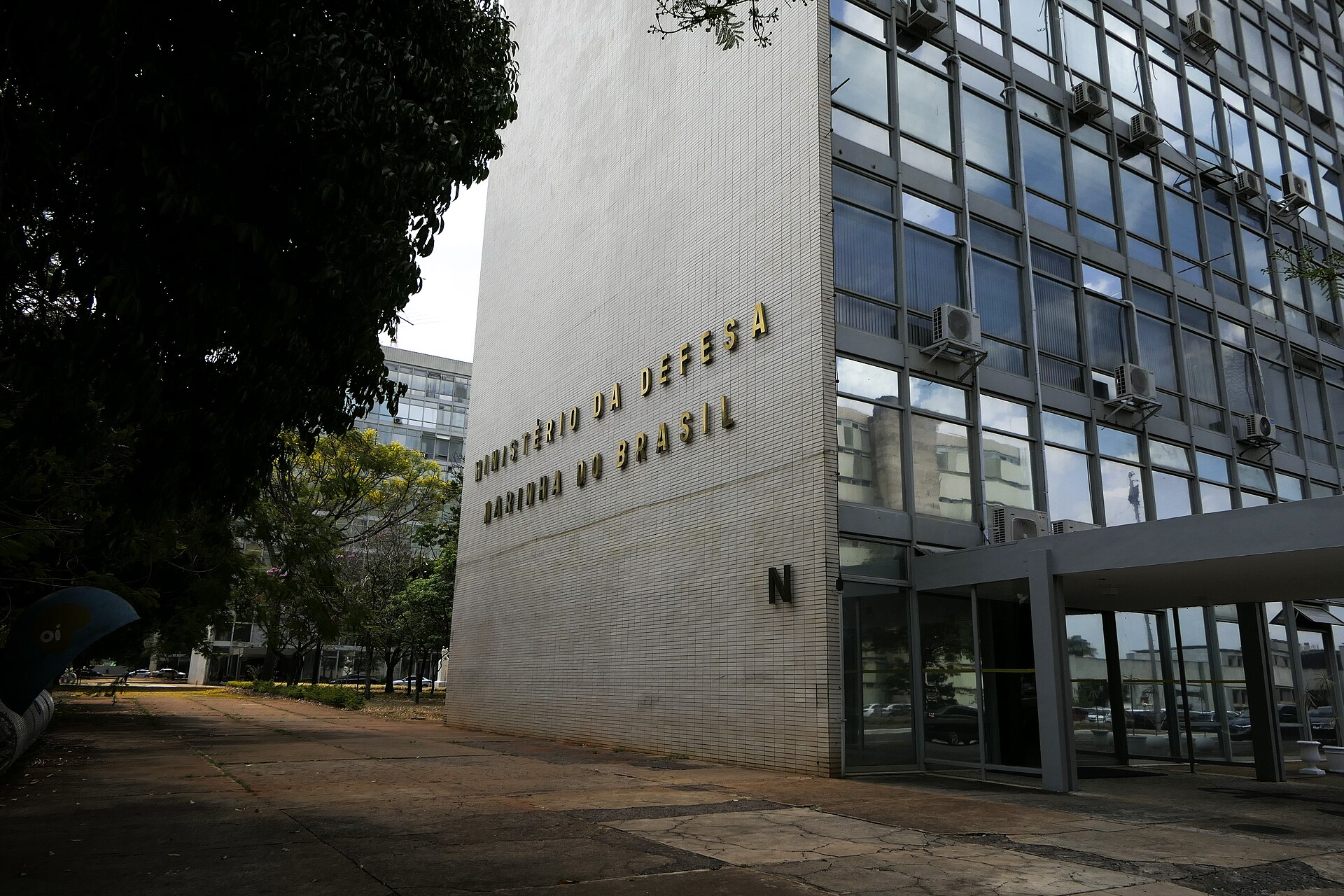 Corner of a white-tiled ministry block with glass windows and a sign reading Ministério da Defesa, Marinha do Brasil