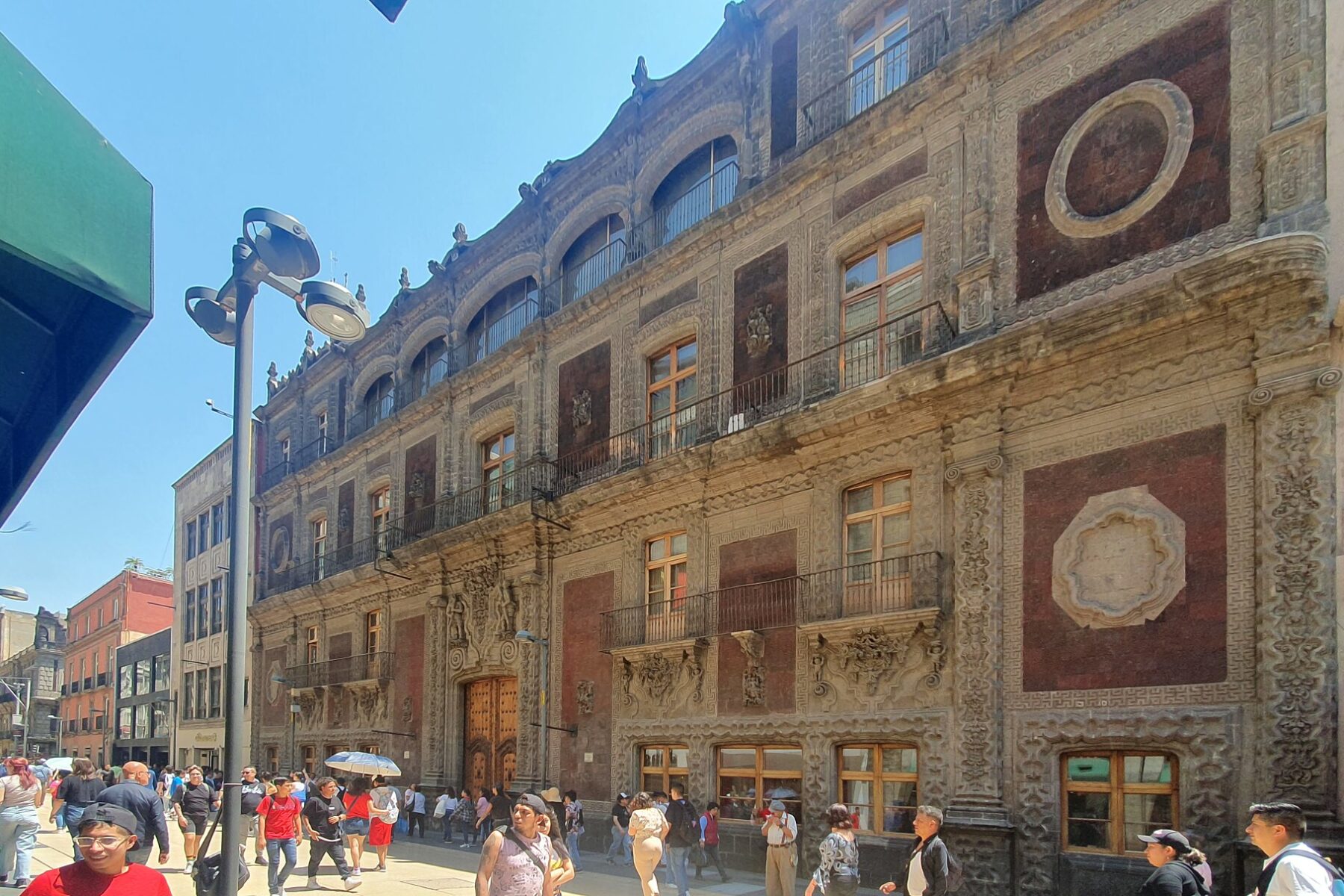 The baroque Palacio de Iturbide facade on a busy pedestrian street in central Mexico City