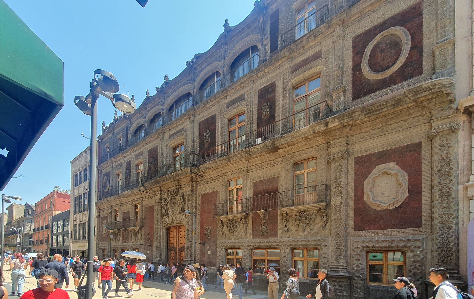 The baroque Palacio de Iturbide facade on a busy pedestrian street in central Mexico City
