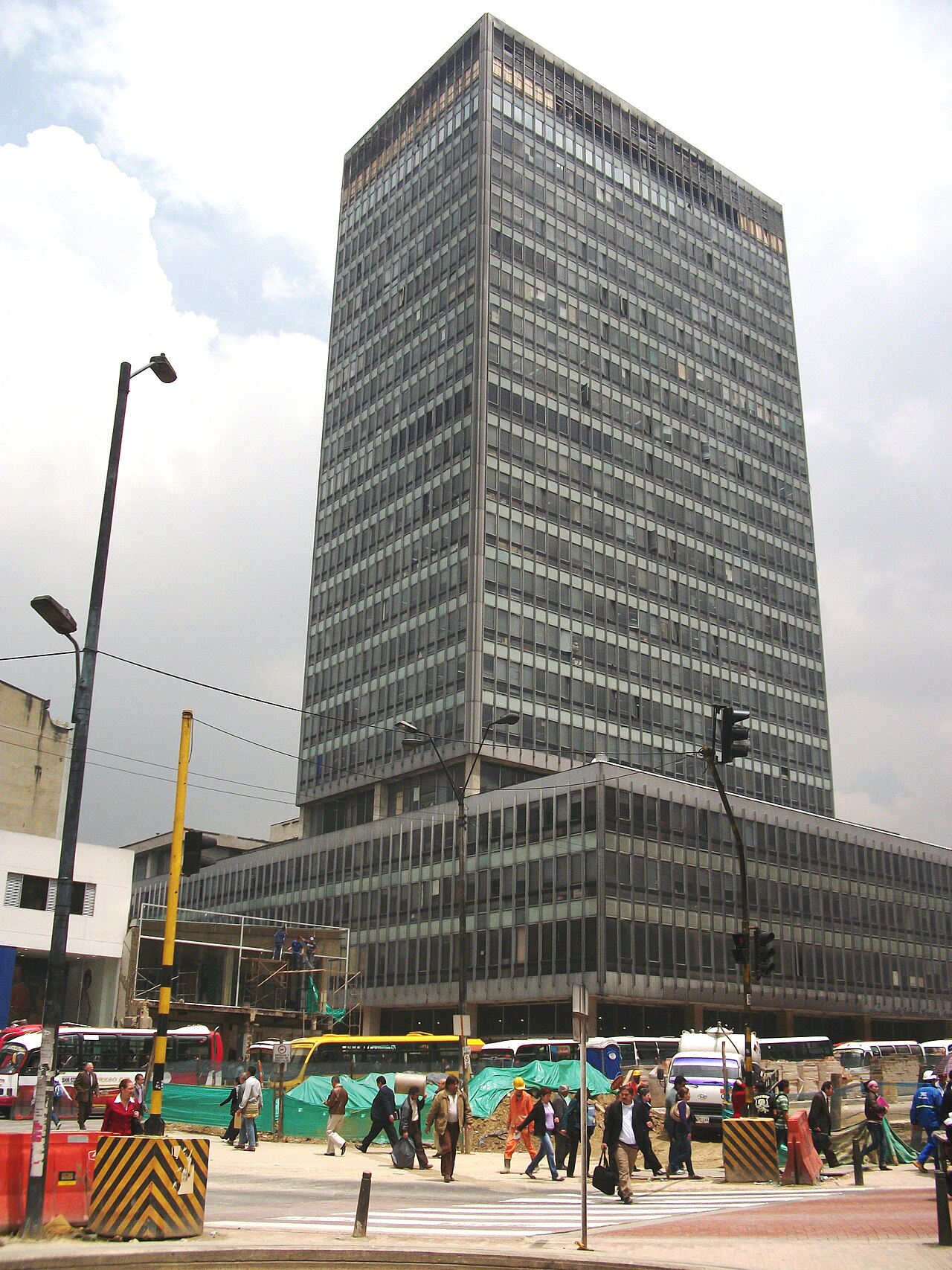 The tall glass-and-steel Banco de Bogotá tower on Carrera Décima in central Bogotá, with pedestrians crossing the street in front