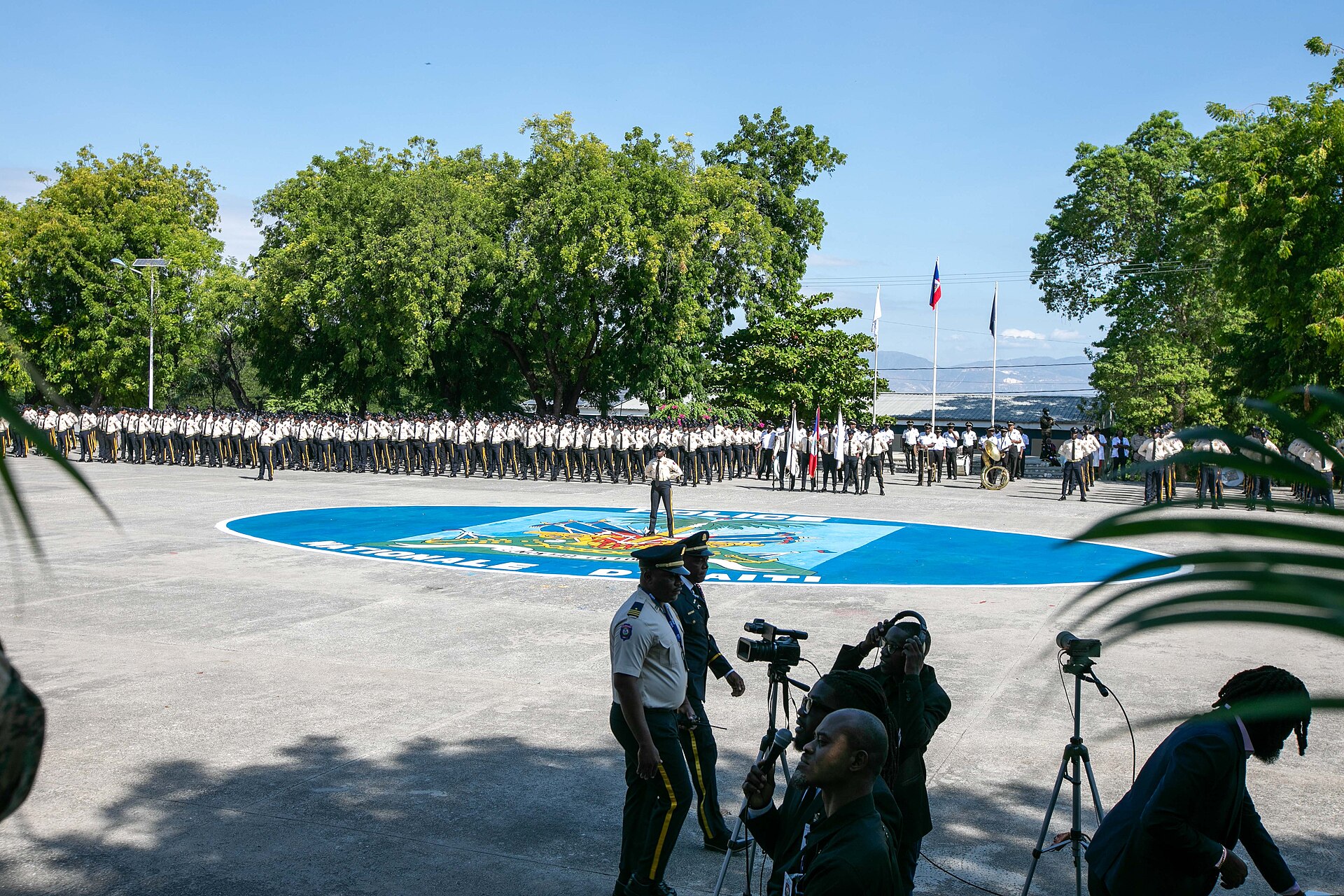 Haitian National Police graduates lined up on a parade ground under a blue sky