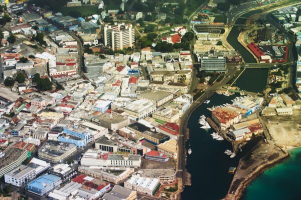 Aerial view of central Bridgetown, Barbados, with the Careenage inlet, moored boats, office blocks and the turquoise sea at the edge of the city.
