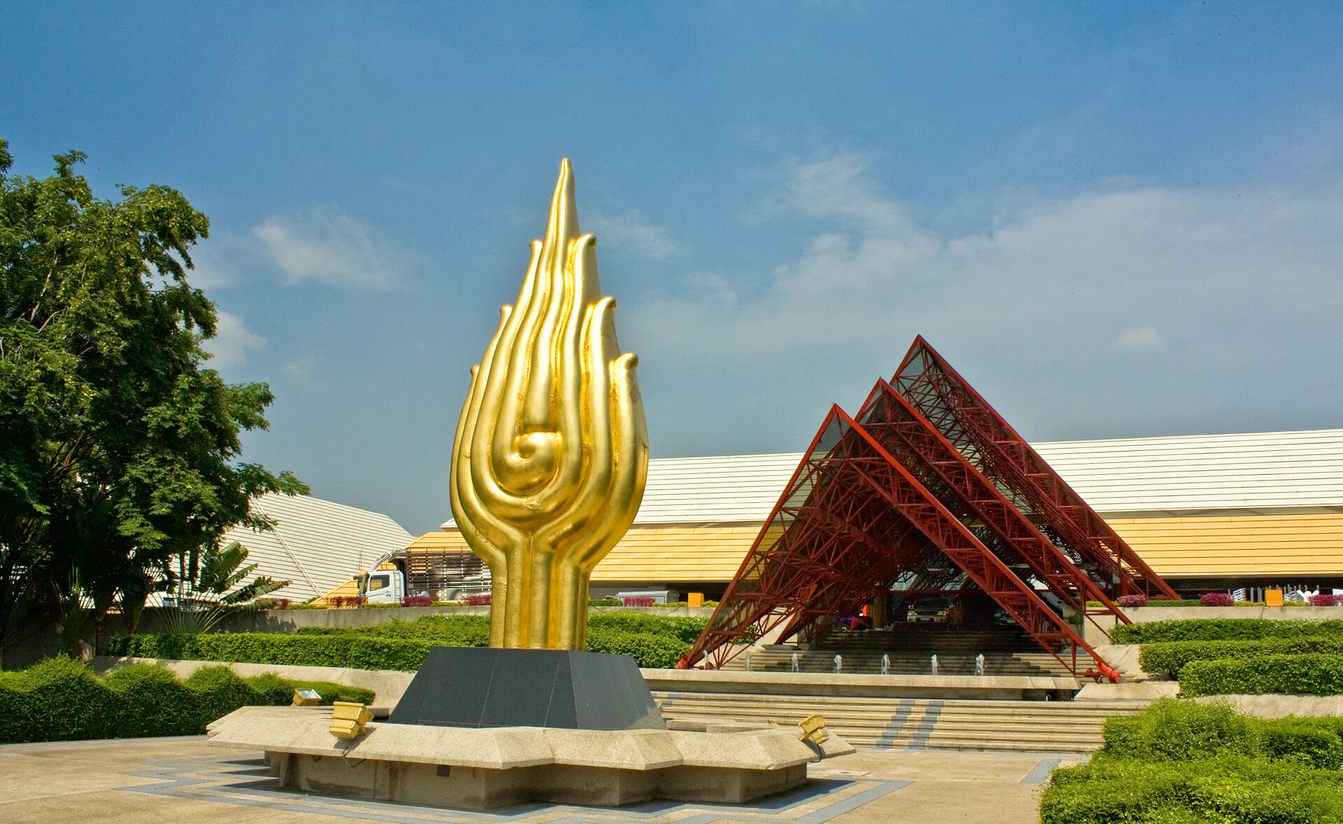 The red-framed entrance and golden sculpture at the Queen Sirikit National Convention Center in Bangkok, Thailand