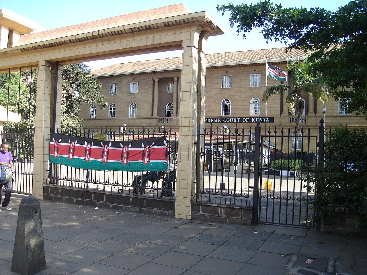 Entrance gate of the Supreme Court of Kenya building in Nairobi, with a Kenyan flag banner on the fence