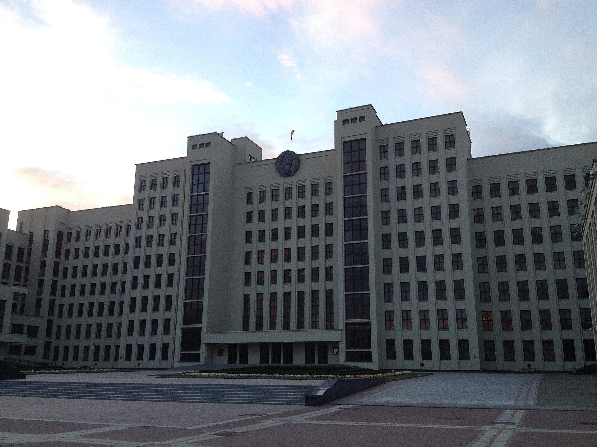 The grey facade of the House of Government in Minsk under an evening sky