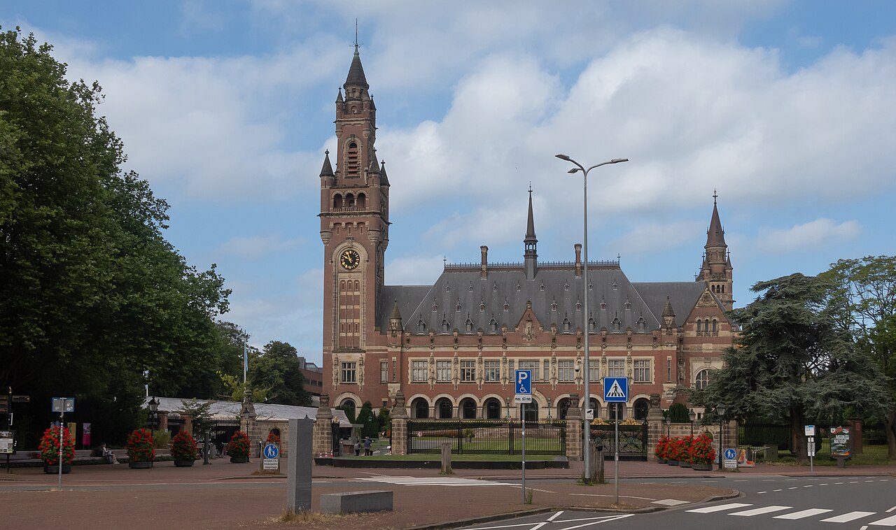 The Peace Palace in The Hague, the red-brick seat of the International Court of Justice, seen across a street.