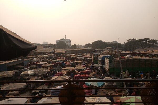 Trucks loaded with sacks and market stalls under umbrellas at the Dantokpa market in Cotonou, Benin