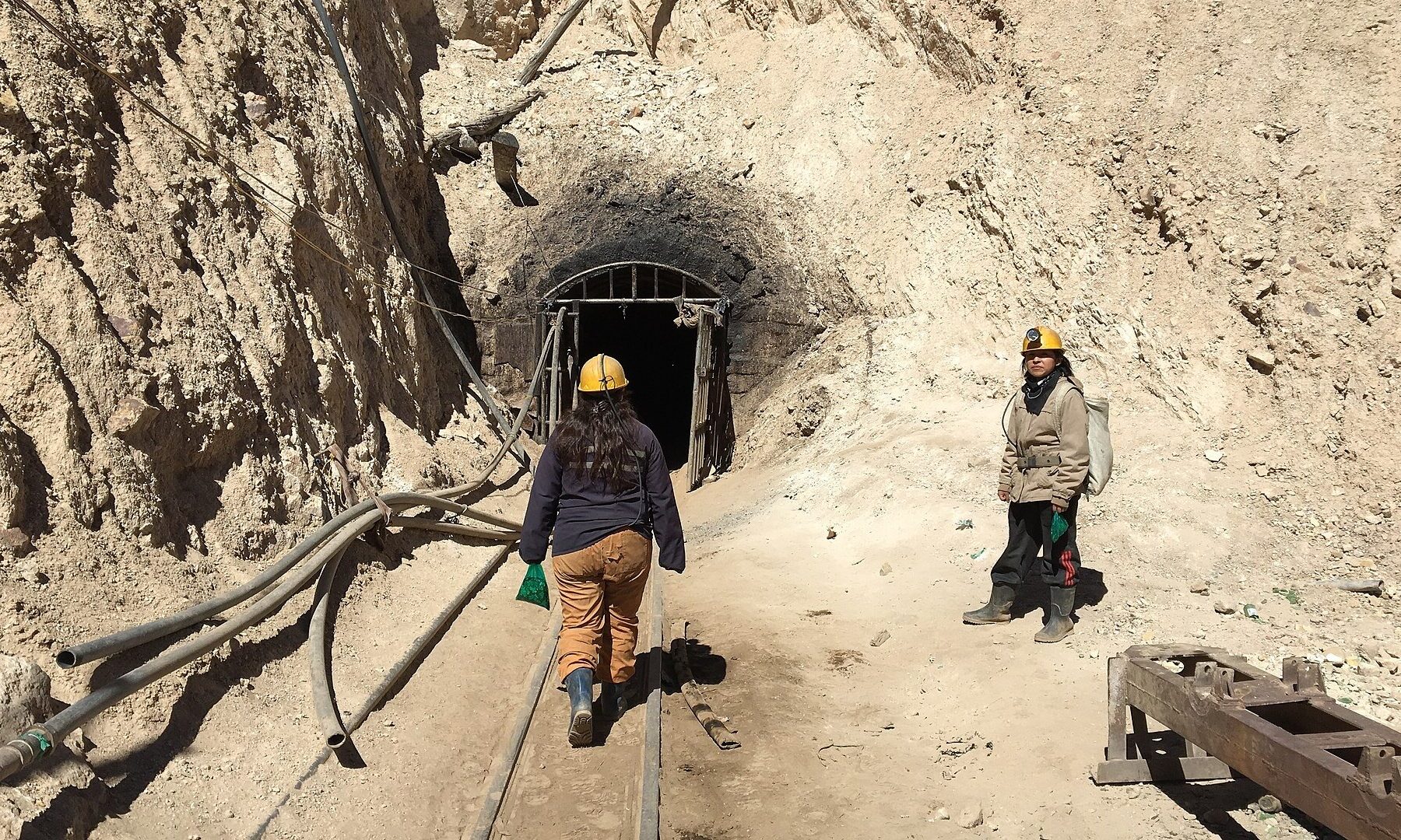 Bolivia mining deaths: a tunnel entrance on the Cerro Rico mountain above Potosí, with rails and air hoses leading inside