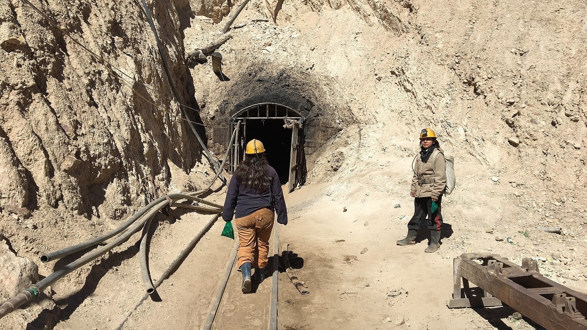 Bolivia mining deaths: a tunnel entrance on the Cerro Rico mountain above Potosí, with rails and air hoses leading inside