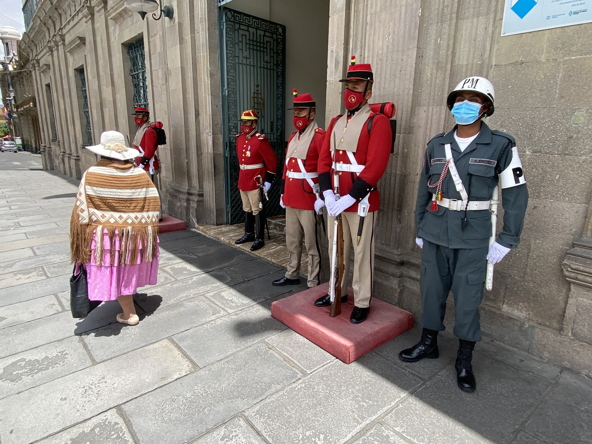 Soldiers and honour guards in red uniforms stand outside the Palacio de Gobierno in La Paz, Bolivia