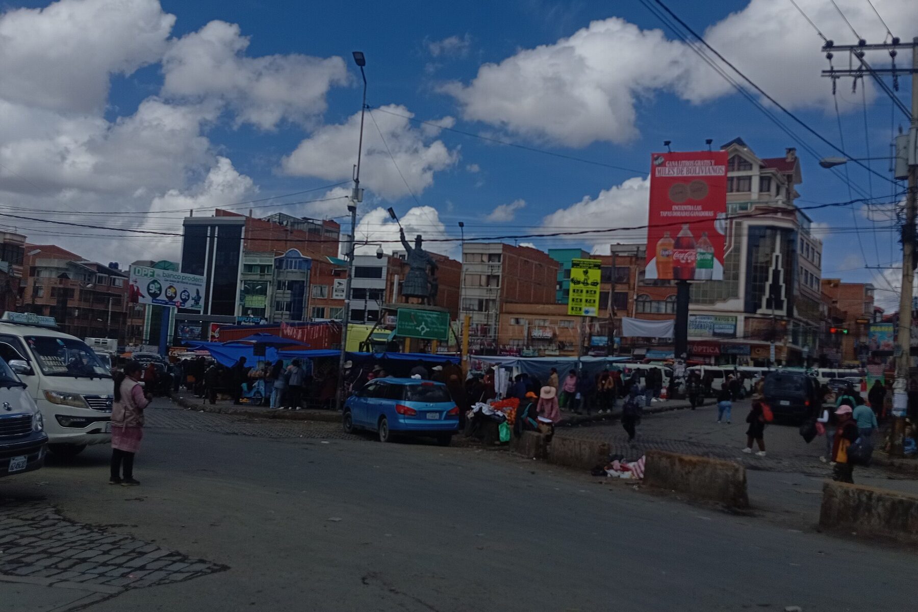 Minibuses, cars and street stalls at a roundabout in the Ballivián area of El Alto, Bolivia