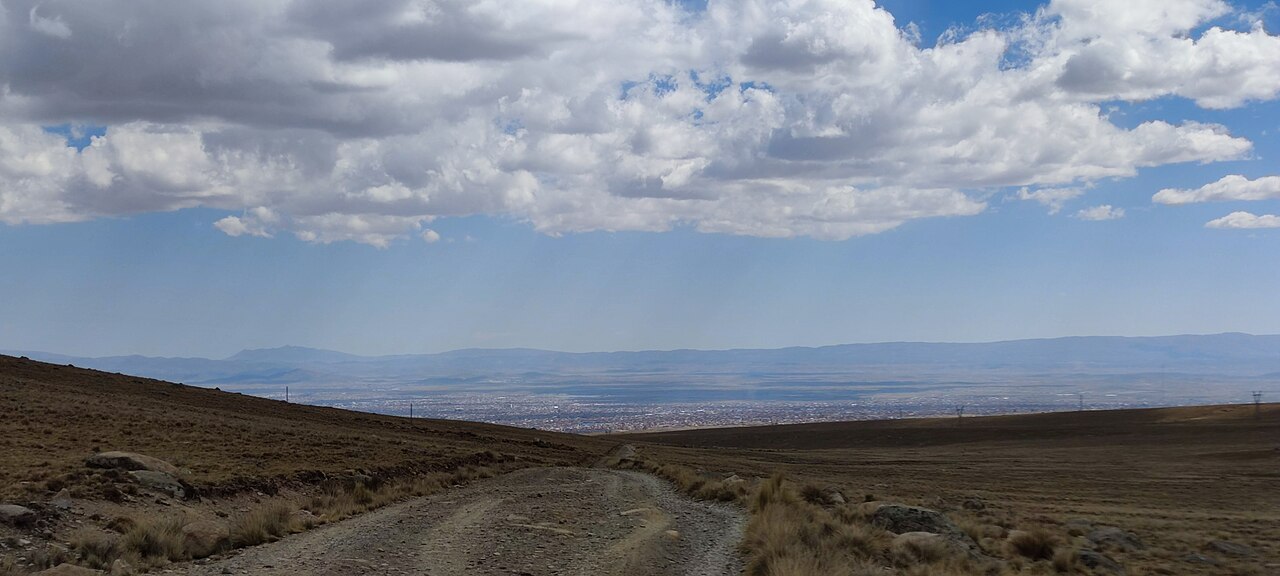 El Alto spread across the Altiplano plateau above La Paz, seen from a dirt road in the hills