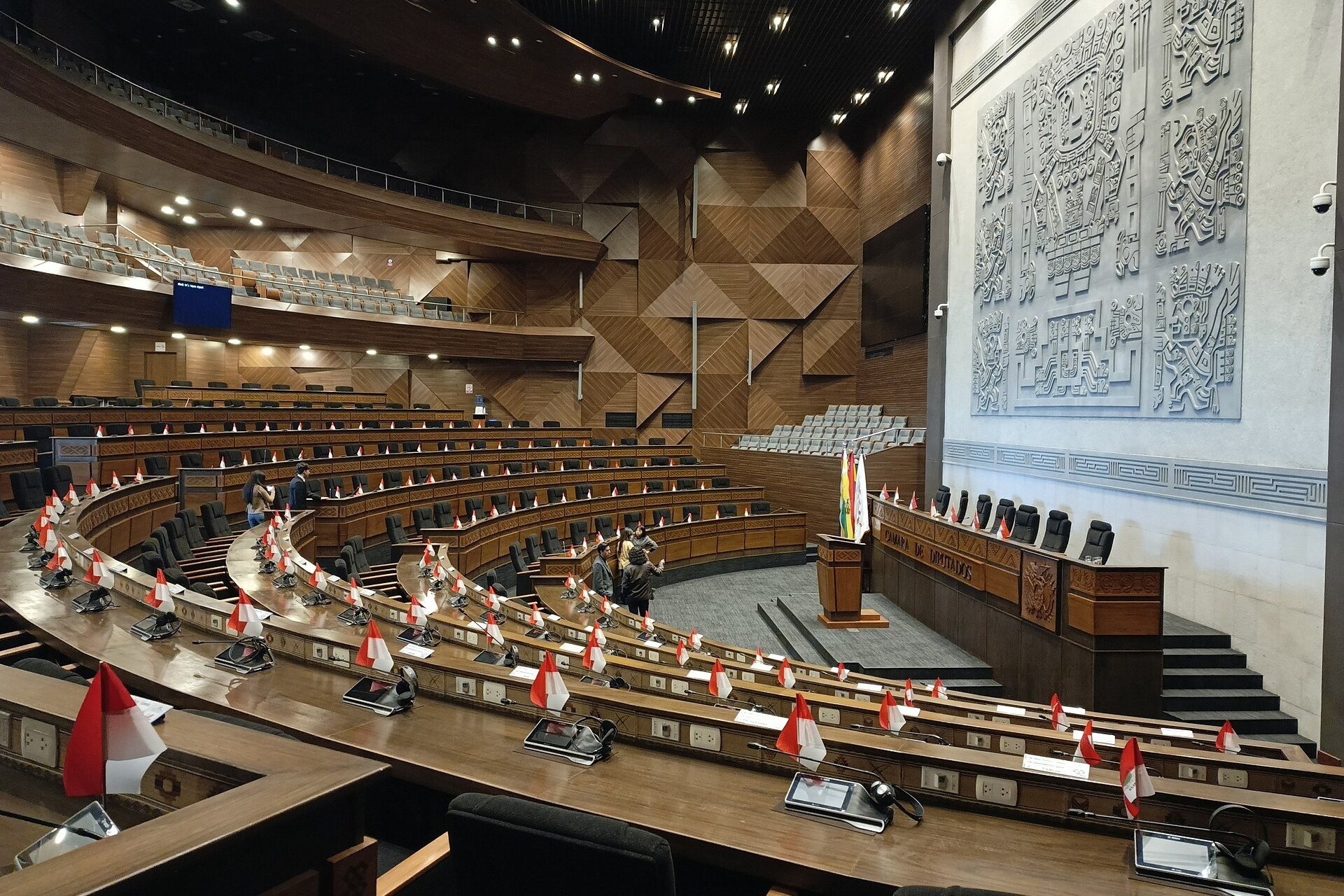 The empty hemicycle of Bolivia's Chamber of Deputies in the new Legislative Assembly building in La Paz, with a large stone relief on the wall