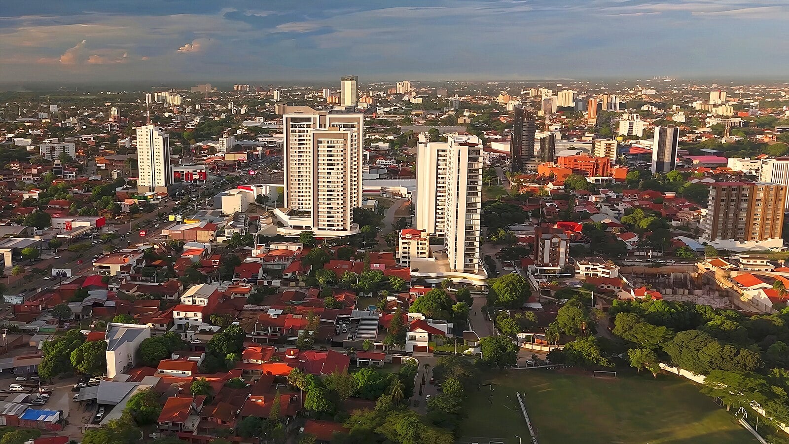 Aerial view of high-rise buildings and red-roofed houses in Santa Cruz de la Sierra, Bolivia, at sunset