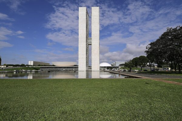 The twin towers and domes of the National Congress in Brasília across a reflecting pool