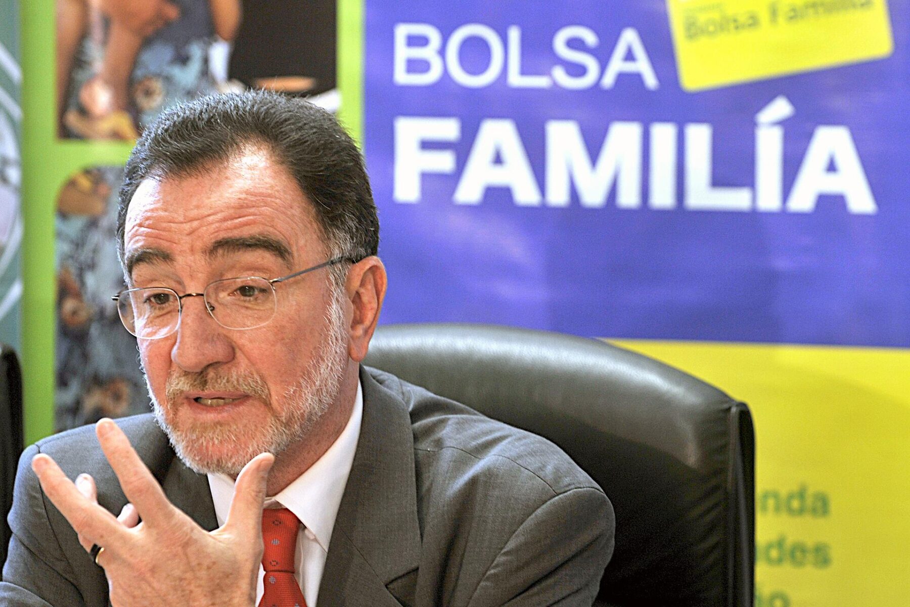 Patrus Ananias, then Brazil's social development minister, speaking in front of a Bolsa Família backdrop in Brasília in 2009