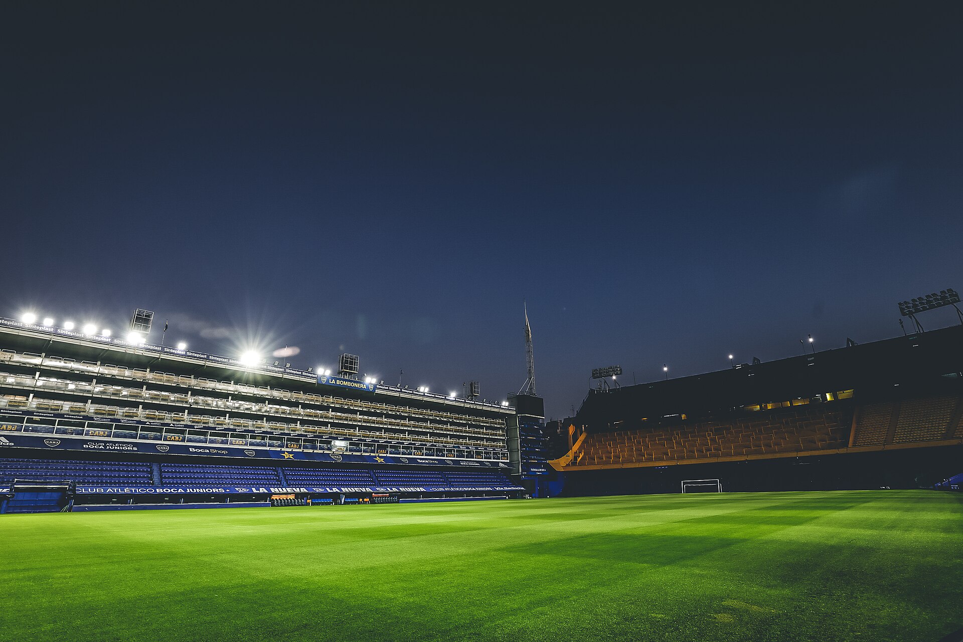 The floodlit pitch and stands of La Bombonera in Buenos Aires at dusk