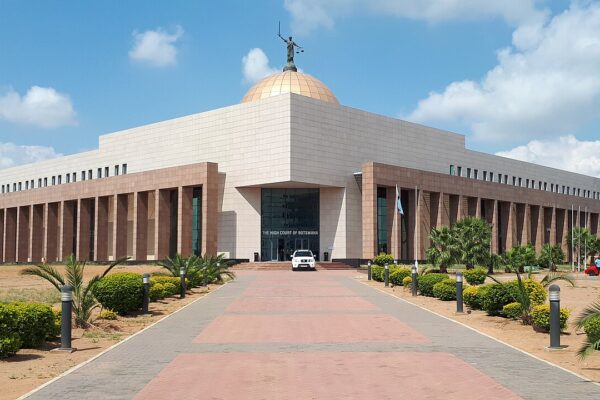 The domed High Court of Botswana building in Gaborone, with a statue of Lady Justice on top and a paved path leading to the entrance