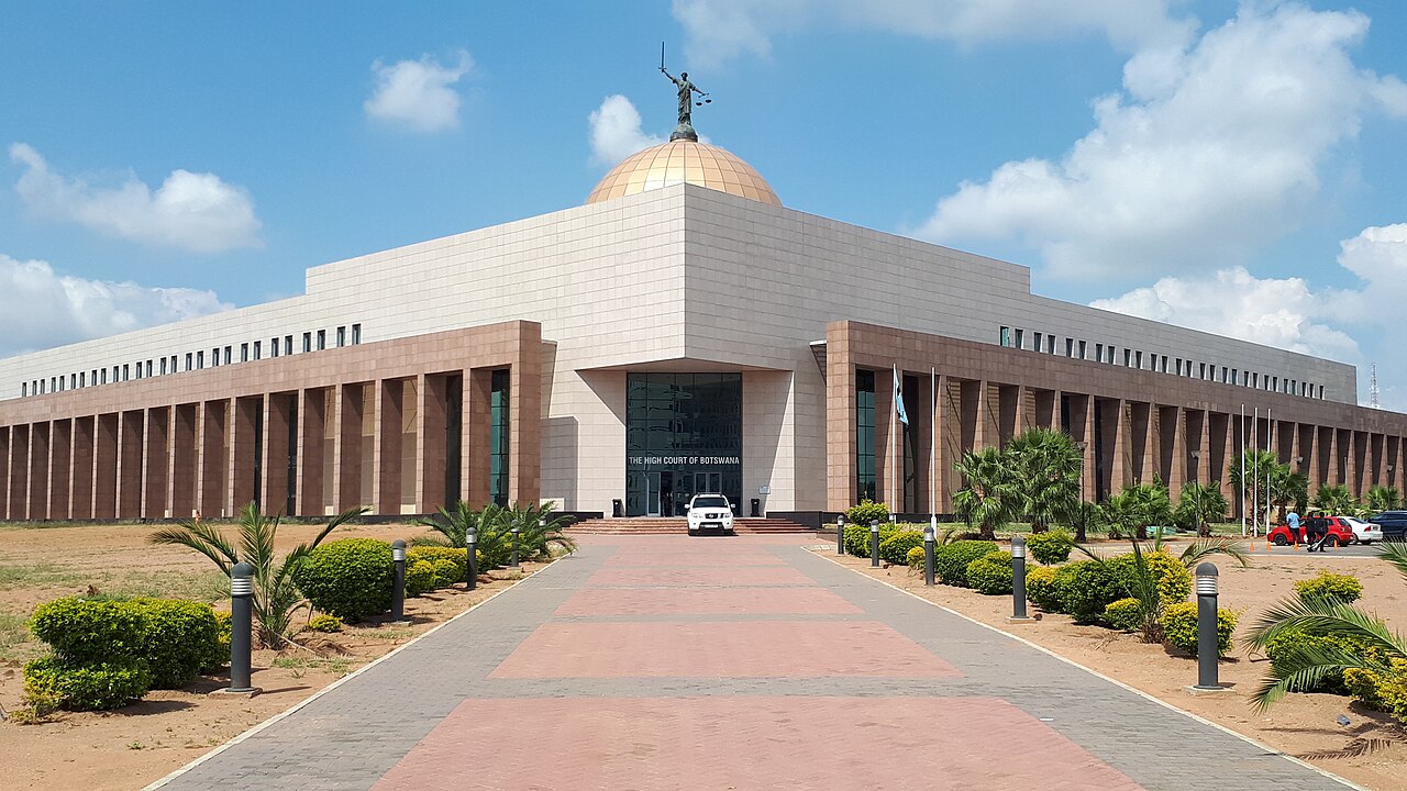 The domed High Court of Botswana building in Gaborone, with a statue of Lady Justice on top and a paved path leading to the entrance
