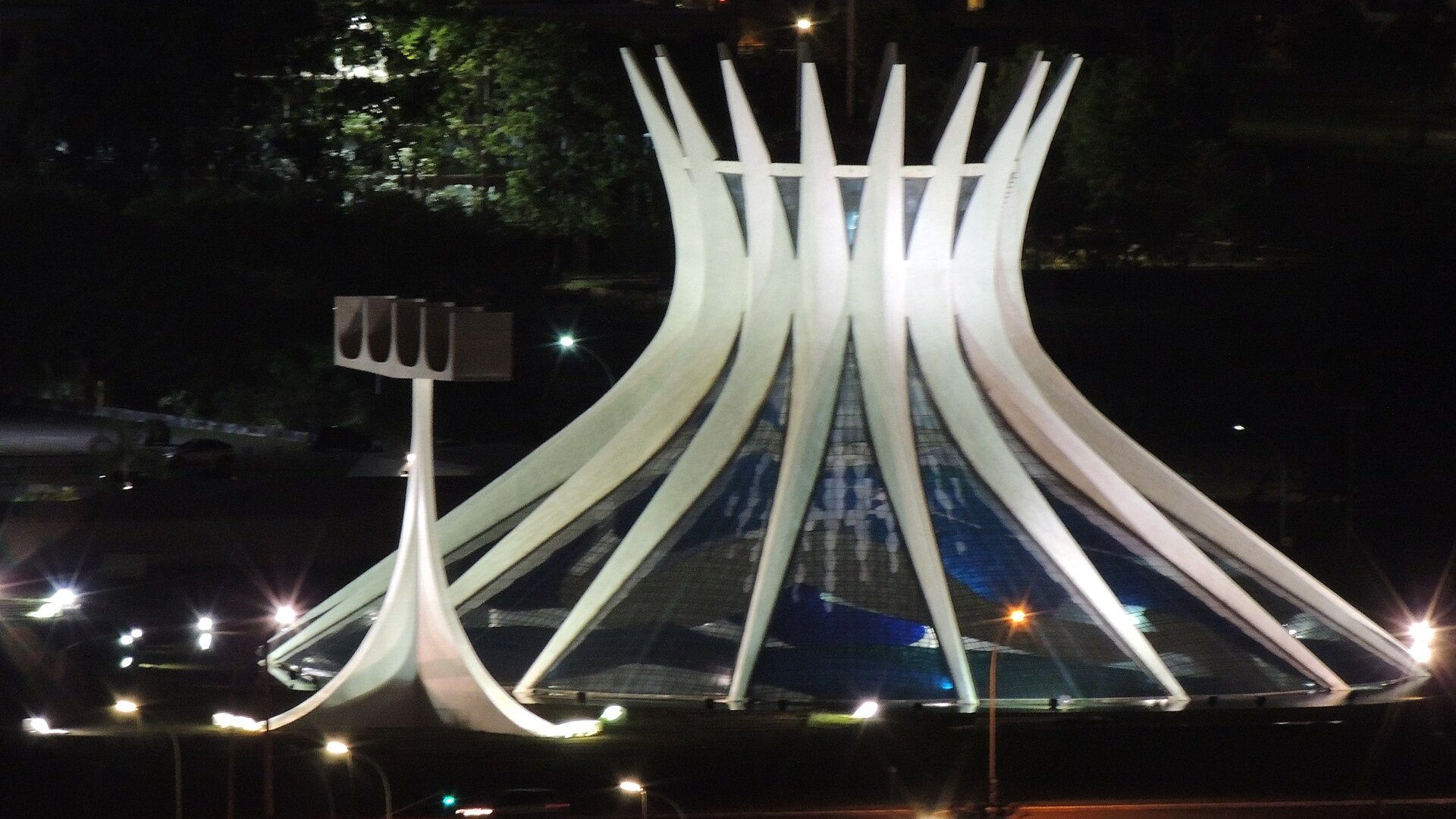 Metropolitan Cathedral of Brasília lit at night, its concrete ribs curving upward