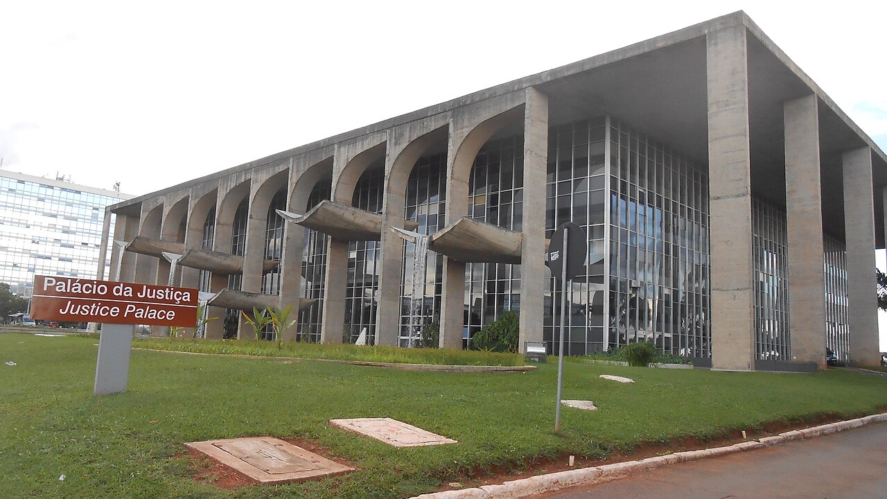 The Palácio da Justiça in Brasília, a concrete building with arches, glass walls and water spouts, behind a lawn and a sign