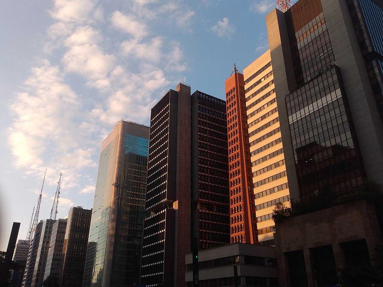 Office towers along Avenida Paulista in São Paulo under a blue sky with scattered clouds