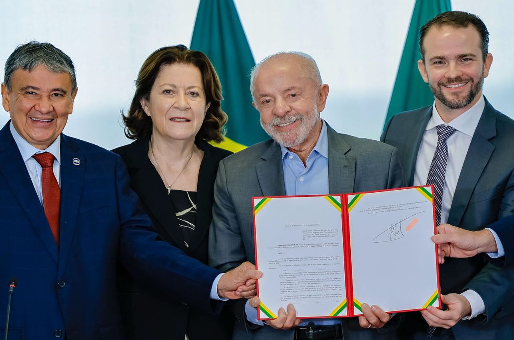 President Lula holds a signed decree at the Planalto Palace, with ministers at his side