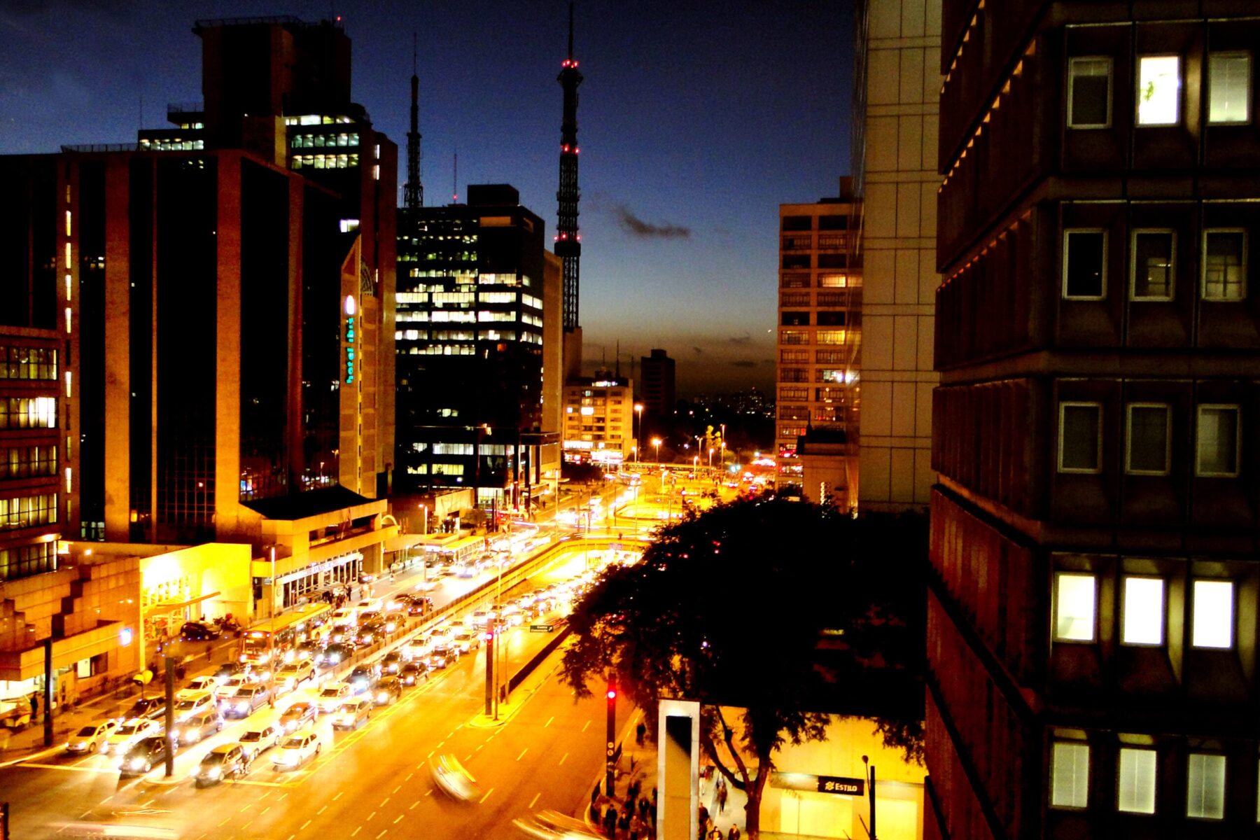 Avenida Paulista in São Paulo at dusk with traffic and lit office towers