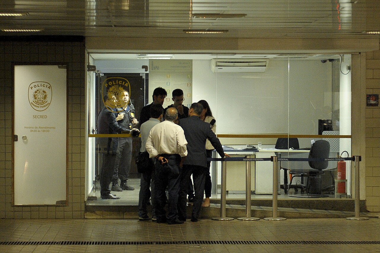 Federal Police officers and plain-clothes agents at a glass-fronted Senate police office in Brasília