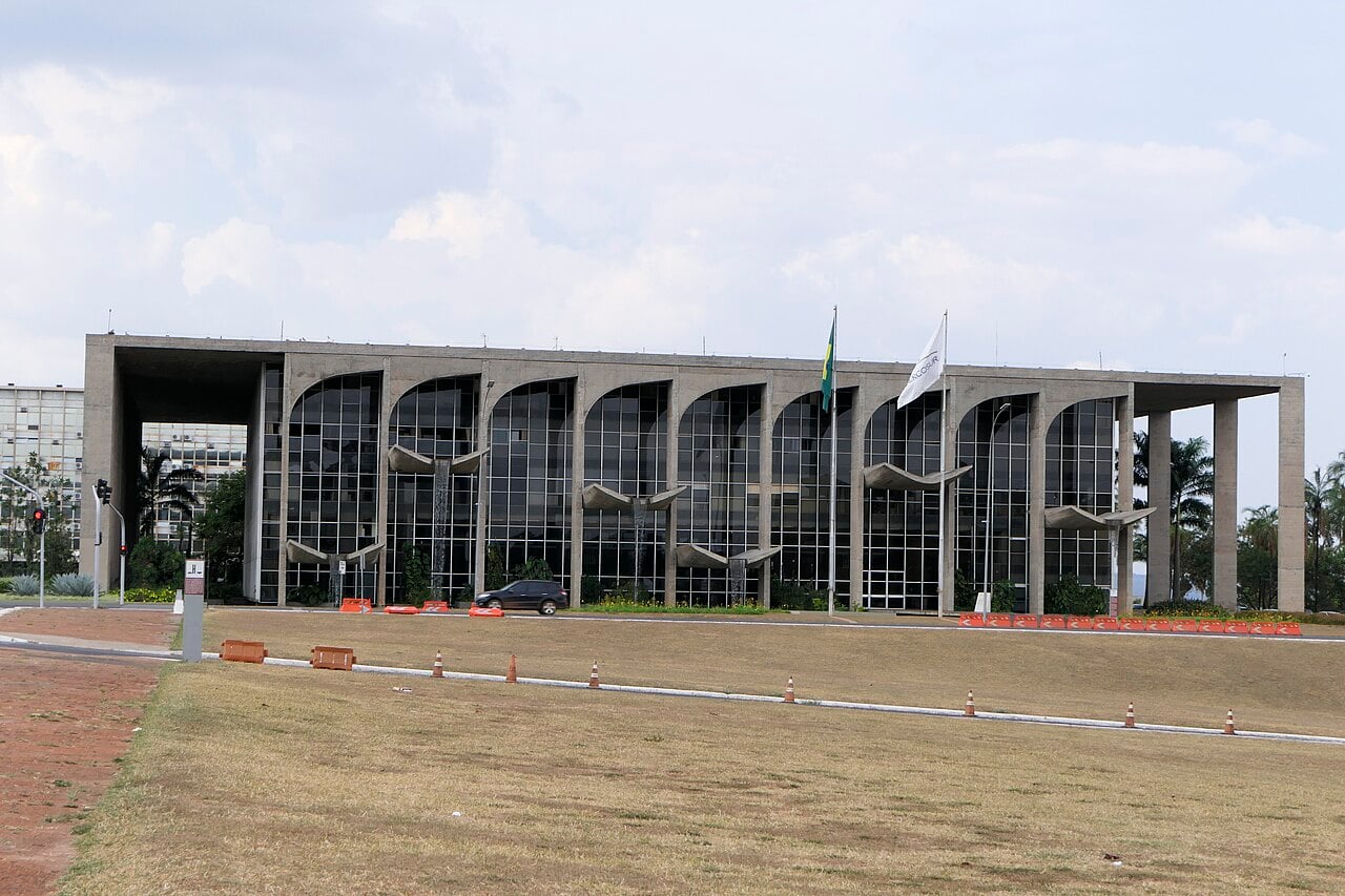 The Palácio da Justiça in Brasília, headquarters of Brazil's Ministry of Justice, seen across a lawn under a cloudy sky
