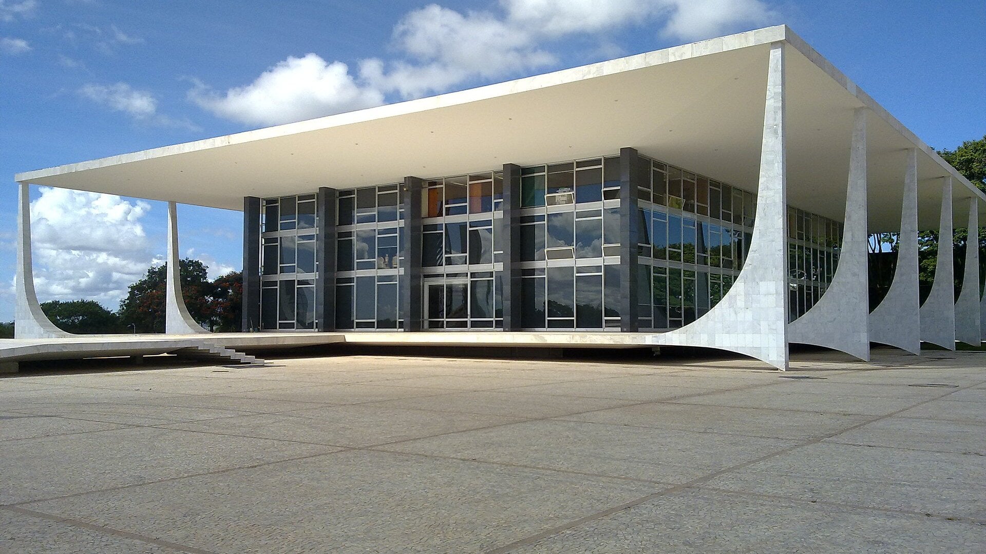 The white marble and glass building of Brazil’s Supreme Federal Court in Brasília under a blue sky, seen from its plaza
