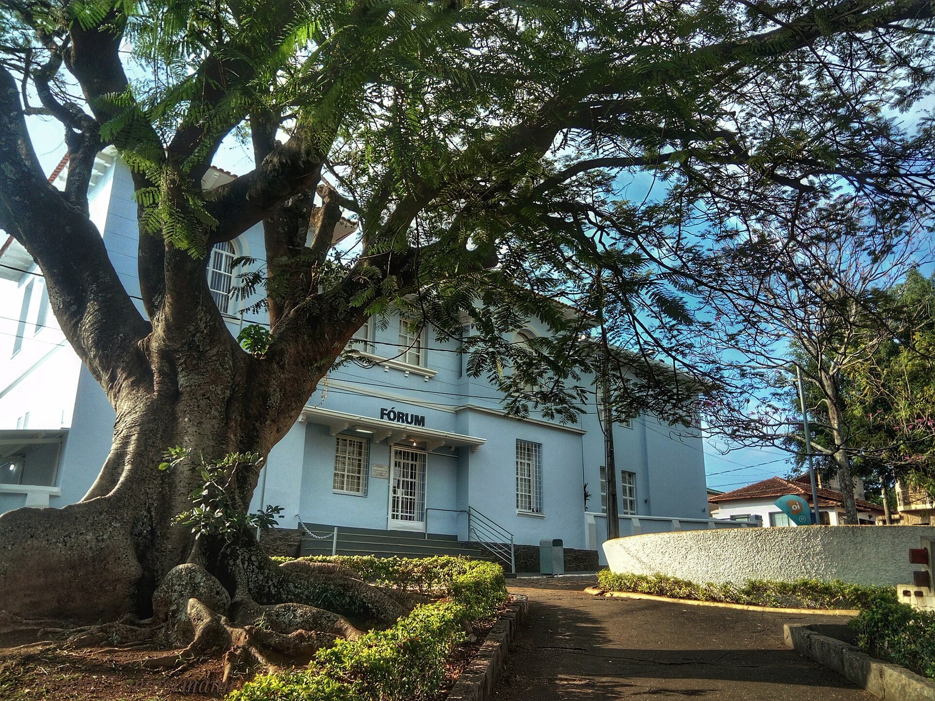 The Fórum, the court building of Botelhos, a town in Minas Gerais state, Brazil, shaded by a large tree