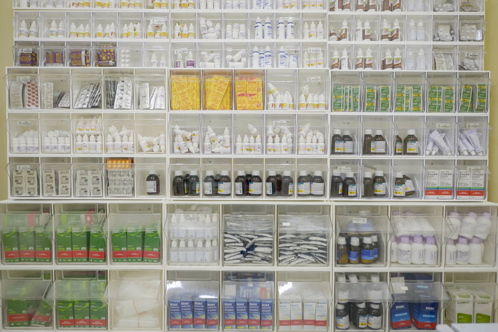 Wall of labelled medicine boxes and bottles in a pharmacy storeroom in Brazil, with Portuguese labels