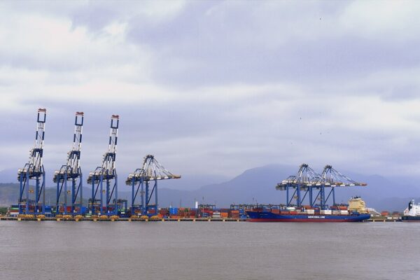 Container cranes and a cargo ship at the Port of Santos in São Paulo state, Brazil, under a cloudy sky