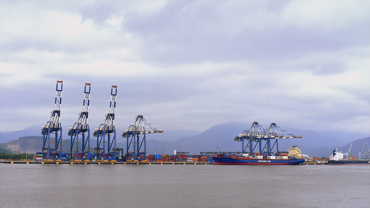 Container cranes and a cargo ship at the Port of Santos in São Paulo state, Brazil, under a cloudy sky